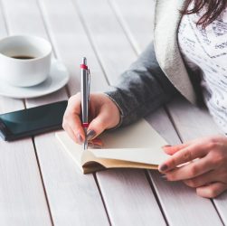 Woman, write, notepad — General Ledger for Rental Properties Keeps You Prepared Year-Round