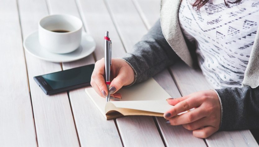 Woman, write, notepad — General Ledger for Rental Properties Keeps You Prepared Year-Round