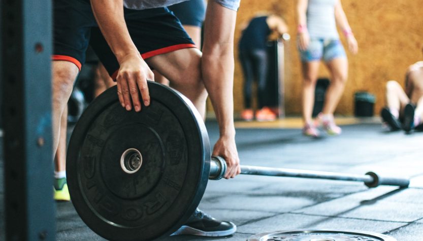 Focused weightlifting session in a gym with diverse athletes participating indoors. — Improve Posture Naturally with the Help